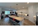 Contemporary kitchen with barstool seating at the island and a view into the living area at 25240 Keygrass Ct, Punta Gorda, FL 33955