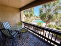 Balcony with a table and chairs, overlooking the tropical landscape and community pool at 3447 Clark Rd # 246, Sarasota, FL 34231