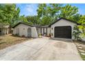 Features a clean white facade, dark-colored garage door, and low-maintenance landscaping at 4233 Abaco Ct, New Port Richey, FL 34653