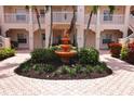 Picturesque courtyard with a tiered fountain, lovely landscaping, and brick-paved walkway at 4264 Central Sarasota Pkwy # 116, Sarasota, FL 34238