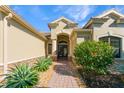 Inviting front entryway with a beautiful archway, double doors, and professionally landscaped garden at 4579 Tuscana Dr, Sarasota, FL 34241