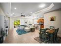 Spacious living room with tray ceiling, fan, tile floors, and an open concept to the kitchen and dining at 4734 Claremont Park Dr, Bradenton, FL 34211