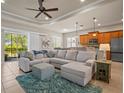 Comfortable living room featuring a large sectional sofa, tray ceiling, and plenty of natural light at 4734 Claremont Park Dr, Bradenton, FL 34211