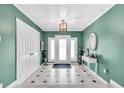 Inviting foyer with a unique tiled floor, green walls, and a decorative light fixture at 5012 Eastchester Dr, Sarasota, FL 34234