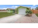 View of the side of the home with a white, one-car garage and a paved driveway at 5353 Starwood Pl, Sarasota, FL 34232
