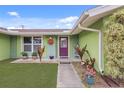 Close up shot of the front porch featuring colorful decor and a purple front door at 5353 Starwood Pl, Sarasota, FL 34232