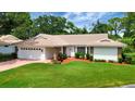 Inviting one-story residence with lush green lawn, brick-accented facade, and attached two-car garage at 5705 Garden Lakes Majestic, Bradenton, FL 34203