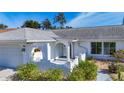 Home exterior featuring an arched entry, attached garage, and mature landscaping at 6012 11Th W Ave, Bradenton, FL 34209
