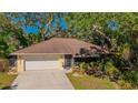 Charming single-story home with a two-car garage and mature landscaping at 620 Burke Rd, Venice, FL 34293