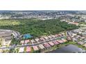Aerial view of a residential area featuring a lake and community tennis courts, surrounded by lush greenery at 6240 Falcon Lair Dr, North Port, FL 34287