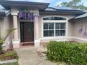 Charming home featuring a welcoming front entrance with decorative floral accents, solar panels, and a cozy butterfly bench at 652 N Elm St, Englewood, FL 34223