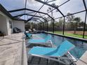 Relaxing screened-in pool area with chaise lounges, a jacuzzi, and an umbrella for shade at 6875 Beckwith Ave, North Port, FL 34291