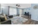 Open living room features a decorative rug, a ceiling fan, light blue walls, and lots of natural light at 816 Wabash Rd, Venice, FL 34293