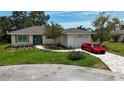 Inviting home with a landscaped front yard, paved walkway, white garage, and red car in the driveway at 8808 44Th Avenue W Dr, Bradenton, FL 34210