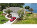 Beautiful waterfront home with a well-manicured lawn and a long driveway leading to the attached garage at 8808 44Th Avenue W Dr, Bradenton, FL 34210