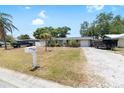 Quaint home on a lot with mature landscaping and a long gravel driveway at 10827 Village Green Ave, Seminole, FL 33772
