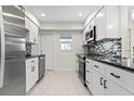 Renovated kitchen features white cabinets, stainless steel appliances, and a stylish backsplash at 111 Whispering Sands Cir # V38, Sarasota, FL 34242
