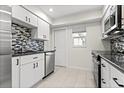 Modern kitchen with stainless appliances, granite counters, and stylish backsplash at 111 Whispering Sands Cir # V38, Sarasota, FL 34242