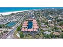 An aerial view shows these condos feature beach proximity, tennis courts, and a pond at 1159 Lake House Cir # C120, Sarasota, FL 34242