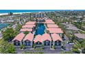 An aerial view shows lush landscaping, beach proximity, tennis courts, and a pond for these condos at 1159 Lake House Cir # C120, Sarasota, FL 34242