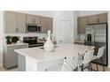 Modern kitchen features stainless steel appliances, sleek countertops, and a spacious island with seating at 15148 Cuzcorro Ct, Nokomis, FL 34275