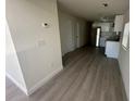 Inviting hallway leading to a modern kitchen featuring new flooring, paint and fixtures at 15233 Omaha St, Hudson, FL 34667
