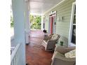 Relaxing front porch with comfortable seating, showcasing charming decor, perfect for enjoying the outdoors at 1526 Ewing St, Nokomis, FL 34275