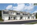 View of townhouses featuring gray exteriors, garages, and landscaped front yards under a cloudy sky at 17409 Haysack Ter, Lakewood Ranch, FL 34211