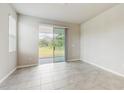 Bright, spacious room with tile floors and a sliding glass door leading to the backyard at 1824 Woodleaf Hammock Ct, Bradenton, FL 34211