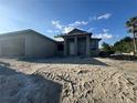 New home under construction featuring an unfinished exterior, visible frame, and a sandy lot at 18274 Grace Ave, Port Charlotte, FL 33948