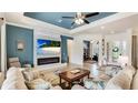 Elegant living room with a fireplace, stone accent wall, and an adjacent view into the office at 20359 Cristoforo Pl, Venice, FL 34293