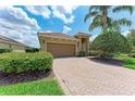 Charming single-story home boasting a brick paver driveway, 2-car garage, lush landscaping, and a barrel tile roof at 207 Winding River Trl, Bradenton, FL 34212