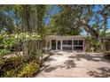 Driveway with lush landscaping and a garage with large windows at 2207 Hickory Ave, Sarasota, FL 34234