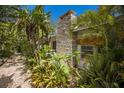 Property's exterior view featuring lush tropical landscaping and custom brickwork at 2207 Hickory Ave, Sarasota, FL 34234
