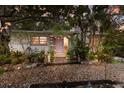 Charming home featuring a pink door, stone pathway, and beautiful tropical landscaping at 2207 Hickory Ave, Sarasota, FL 34234