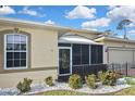 Lovely exterior view of the home featuring a screened-in porch, decorative rock and lush landscape at 2371 Manheim Ave, North Port, FL 34286