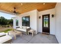 Inviting covered patio with ceiling fan, stylish seating, and rustic wood ceiling at 27510 67Th E Ave, Myakka City, FL 34251