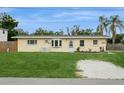 Quaint single-story home featuring a lush green lawn, mature landscaping, and a cozy entrance at 2804 W Mark Dr, Sarasota, FL 34232