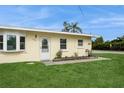 Charming home with well-manicured lawn, blooming plants, and a welcoming front door at 2804 W Mark Dr, Sarasota, FL 34232