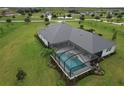 Aerial view of a private screened-in pool with a jacuzzi, surrounded by a well-manicured lawn at 3518 Recurve Cir, Sarasota, FL 34240