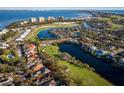 Panoramic aerial view showcases a home near a beautiful waterfront, golf course and mature trees at 3521 Fair Oaks Ln, Longboat Key, FL 34228