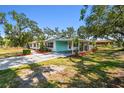 Charming single-story home with a covered, screened-in parking area and mature landscaping at 3619 Elm St, Ellenton, FL 34222