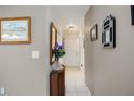 Neutral hallway with tile flooring, decorated with wall art and a decorative cabinet at 3662 Bonaventure Ct, Sarasota, FL 34243