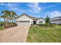 Beautiful one-story home featuring a well-manicured lawn, brick driveway, and a two-car garage at 3679 Santa Caterina Blvd, Bradenton, FL 34211