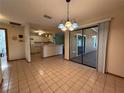 Dining area featuring tile flooring and sliding glass doors leading to an outdoor space, with kitchen bar in the background at 3957 Bearded Oaks Ct, Sarasota, FL 34232
