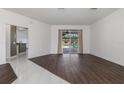 Open living room with hardwood flooring and sliding glass doors to the pool area at 4063 Westbourne Cir, Sarasota, FL 34238