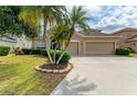 An inviting, tan home has a large driveway leading to a three-car garage surrounded by manicured landscaping and healthy trees at 4211 30Th E Ln, Bradenton, FL 34208