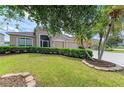 A well-manicured front lawn features a large, beautifully landscaped yard with mature trees, a hedge, and lush green grass at 4211 30Th E Ln, Bradenton, FL 34208