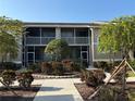 Beautifully landscaped apartment building with sidewalk leading to screened-in lanai at 5330 Hyland Hills Ave # 2314, Sarasota, FL 34241