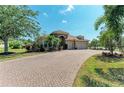 Charming home boasting a brick-paved driveway, lush landscaping, and a welcoming facade at 5439 74Th E Pl, Ellenton, FL 34222